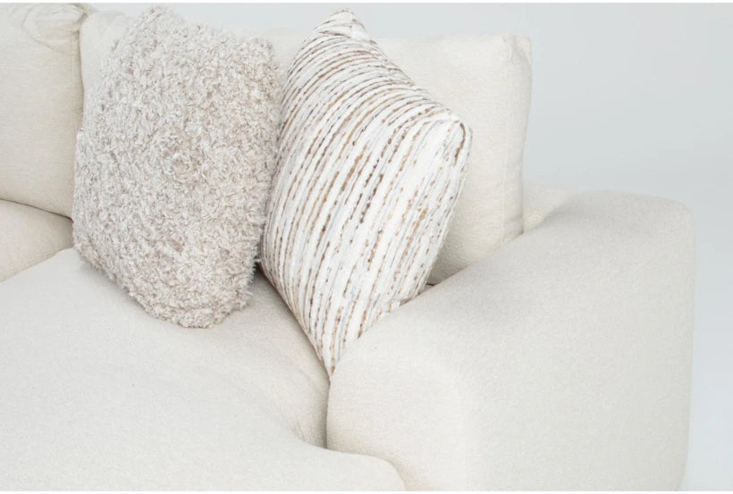 Two textured pillows on a light-colored sofa against a neutral background