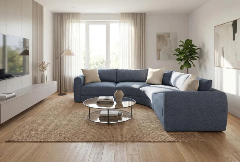 Modern living room with a blue sectional sofa, coffee table, and decorative elements.