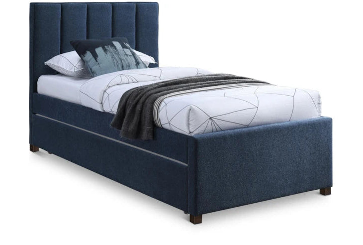 Blue upholstered bed with white bedding and a blanket on a white background