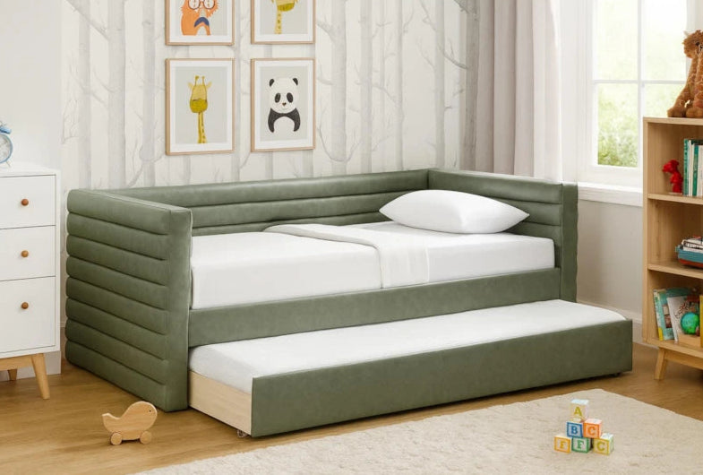 Green upholstered trundle bed in a child's room with toys and books around.