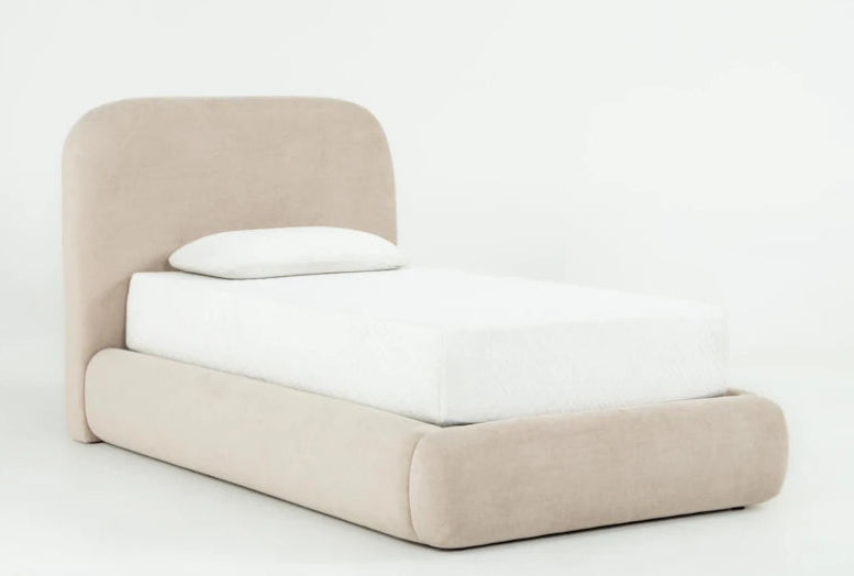Beige upholstered bed with white mattress and pillow on a light gray background