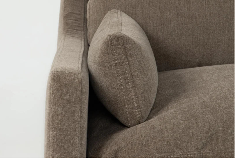 Brown fabric sofa with a textured pillow on a white background