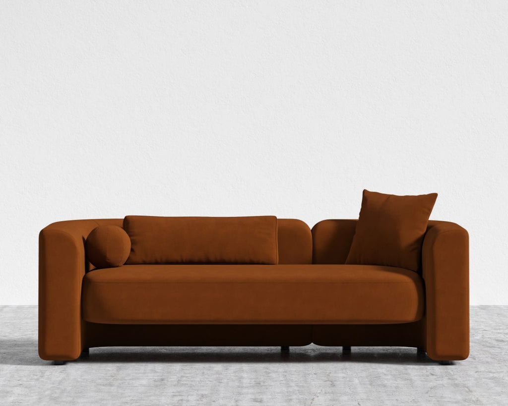 Brown sofa with two cushions on a light gray floor and white background