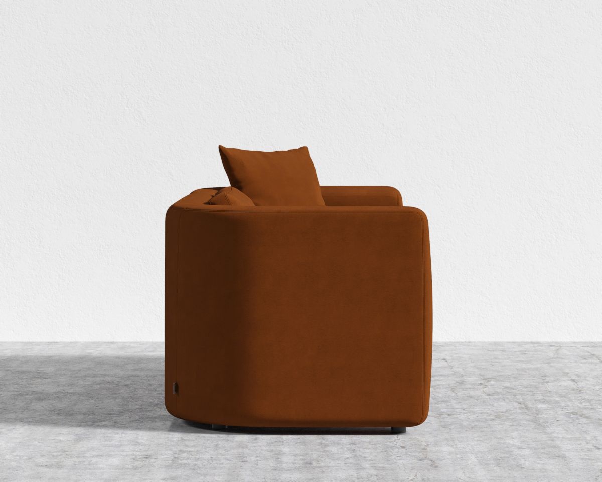 Brown armchair on a light gray floor with a white background