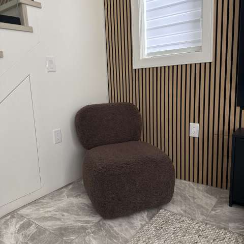Brown textured chair in a room with striped walls and a window.