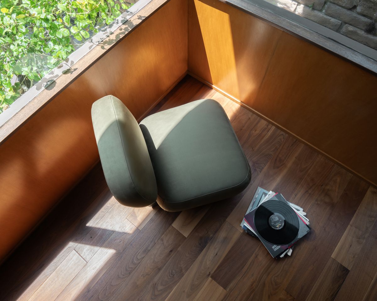 Green office chair on a wooden floor with a window in the background